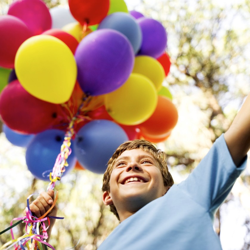 Young Boy Holding a String of Balloons