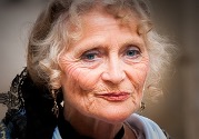 An older woman with blue eyes is smiling.